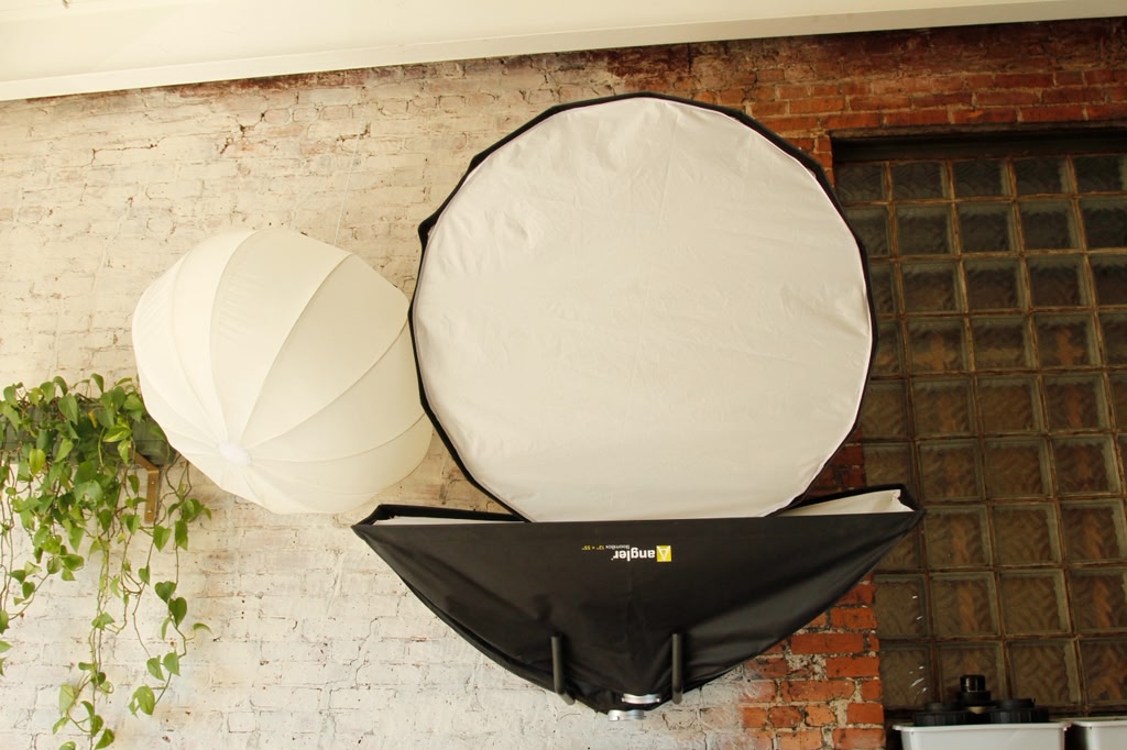 Lantern and parabolic softbox on brick wall